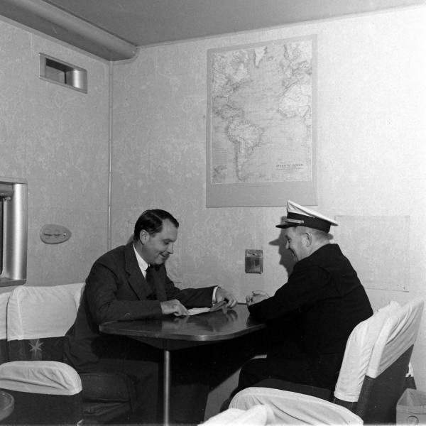 1941 Pan Am founder JuanTrippe sitting in the main lounge  of a Boeing B314 in discussion with a pilot